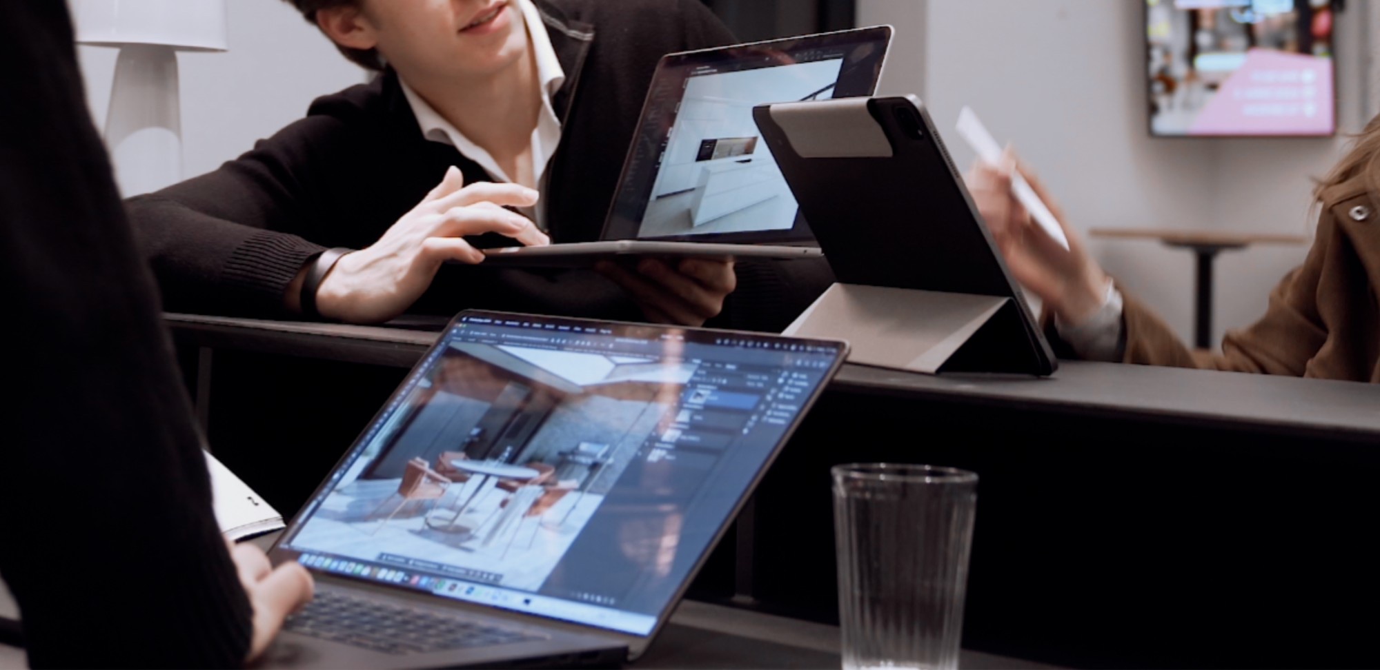 Das FrameScale-Team bespricht Möbelvisualisierungen an Laptop und iPad